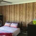 fresh timber wallpaper to cover over an outdated red feature wall